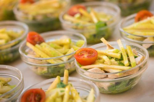 Un grupo de vasos de plástico llenos de pasta y tomates. en htop Molinos Park #htopEnjoy, en Salou