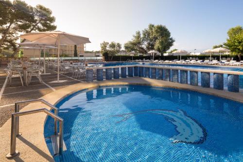 a large blue swimming pool with tables and chairs at htop Molinos Park #htopEnjoy in Salou