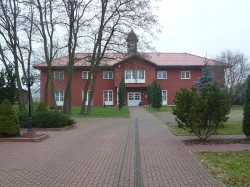 a red house with a clock tower on top of it at Wellnesshotel Legde in Legde