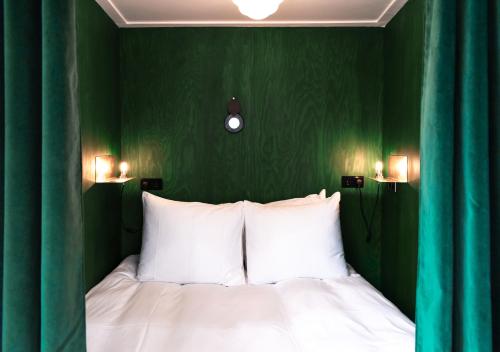 a bedroom with green walls and a bed with white pillows at SWEETS - Overtoomsesluis in Amsterdam