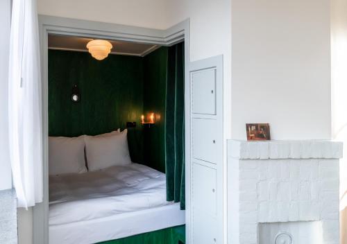 a bedroom with a bed with a green wall at SWEETS - Overtoomsesluis in Amsterdam