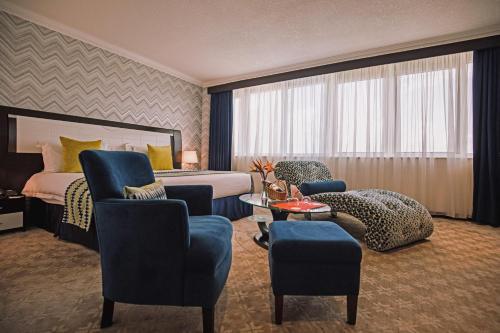 una camera d'albergo con letto, sedie e tavolo di The Panari Hotel - Near Jomo Kenyatta International Airport a Nairobi