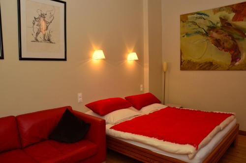 a bedroom with a red bed and a couch at Zentral gelegen - stilvolles Appartment in Moabit in Berlin