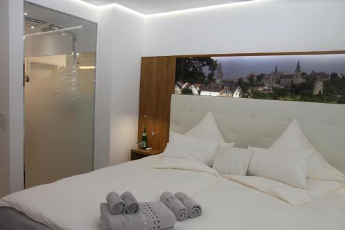 Un dormitorio con una cama blanca con zapatillas. en Natürlich FAMOS Schlafen, en Warburg