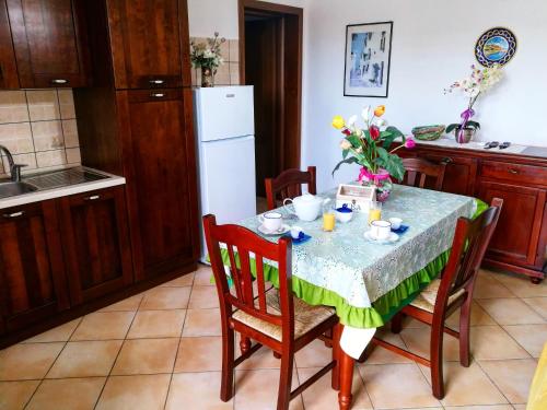uma cozinha com uma mesa e cadeiras com uma mesa e uma cozinha em Stella Marina em Leuca
