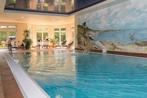 a swimming pool in a house with a painting on the wall at Aparthotel Am See in Plau am See