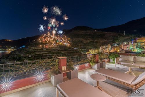 a balcony with fireworks in the sky at night at Il Sogno di Manarola by The First in Manarola