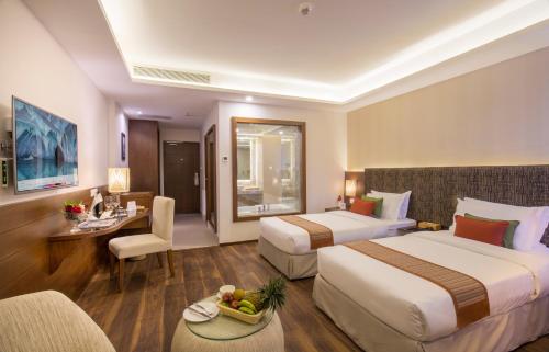una camera d'albergo con due letti, un tavolo e delle sedie di Mountain Glory Forest Resort a Pokhara