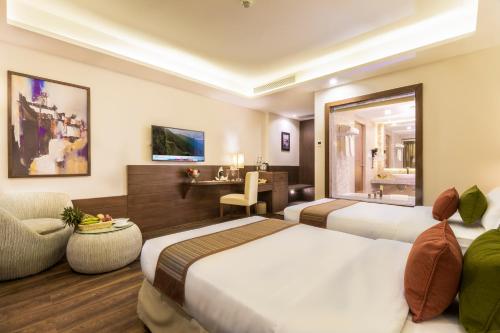 a hotel room with two beds and a chair at Mountain Glory Forest Resort in Pokhara