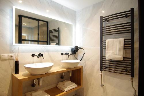 a bathroom with two sinks and a mirror at The Canal Bridge Suites in Amsterdam