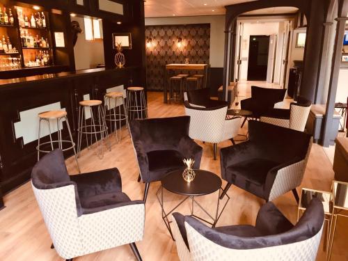 - un bar avec des chaises et des tables dans une pièce dans l'établissement Hotel Le Cardinal Rueil Centre, à Rueil-Malmaison