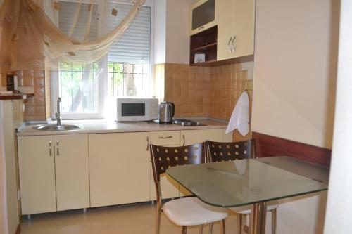 a small kitchen with a table and a microwave at Apartments on Negruzzi 6/2 in Chişinău