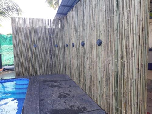 a wooden fence next to a swimming pool at Sea Land Kihim in Alibaug
