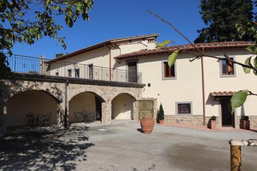 a large white house with a balcony and a patio at Borgo di Villa Cellaia Resort & SPA in Dicomano
