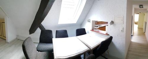 a table and chairs in a room with a white wall at Monteurzimmer Ferienwohnungen Fritsche-Bad Mergentheim in Bad Mergentheim