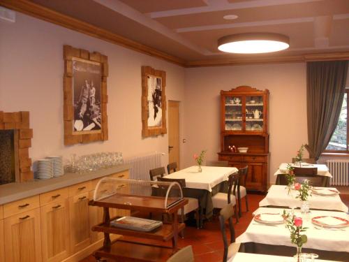 a dining room with two tables and a kitchen at Hotel Bristol in Fiumalbo