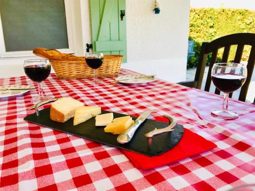 a plate of cheese and wine on a table at La Blatière French Cottages in La Chapelle-Saint-Étienne
