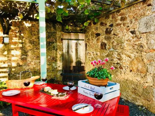 a red table with food and wine glasses on it at La Blatière French Cottages in La Chapelle-Saint-Étienne
