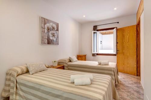 um quarto com três camas e uma janela em Holiday Home Casa Nova by Mauter Villas em Ciutadella