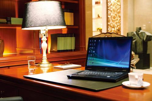 a laptop computer sitting on a desk next to a lamp at San Want Residences Taipei in Taipei