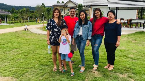 a family poses for a picture in a park at Panutsaya Homestay in Wang Nam Khieo