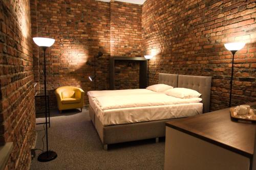 a bedroom with a bed and a brick wall at Stawowa 13 in Katowice