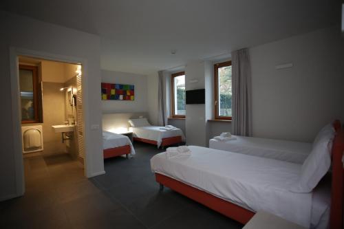 a hotel room with two beds and a bathroom at StraVagante Hostel & Rooms in Verona