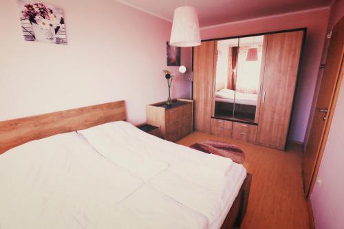 Un dormitorio con una cama blanca y una ventana. en HMM Apartament, en Sibiu