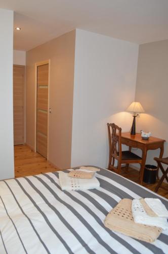 a bedroom with a bed with a table and a chair at le domaine du chaffard in Les Avenières