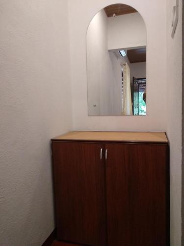 a bathroom with a wooden cabinet and a mirror at Marari Adonis Beach Villa in Mararikulam