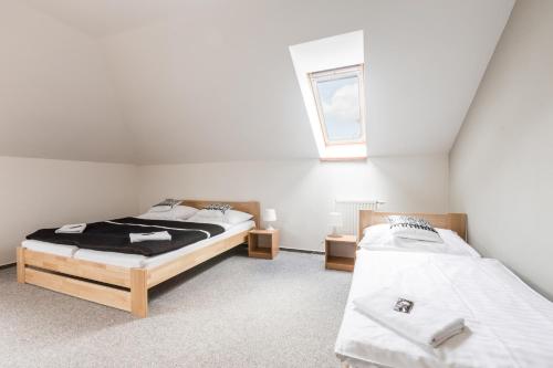 a bedroom with two beds and a window at Pivovar a Penzion GRASEL in Český Rudolec