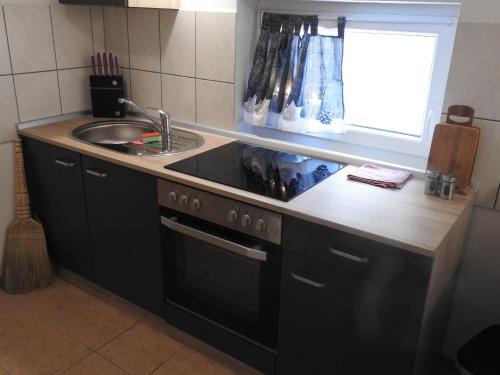a kitchen with a sink and a stove and a window at Ferienwohnungen am Hauptplatz in Pirna