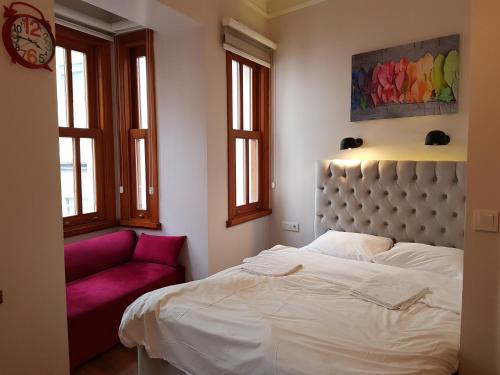 a bedroom with a white bed and a red couch at Linden Houses in Istanbul