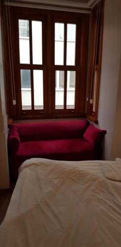 a bedroom with a red couch in front of a window at Linden Houses in Istanbul