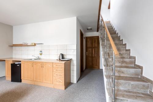 a kitchen with a staircase leading up to a room at Pivovar a Penzion GRASEL in Český Rudolec