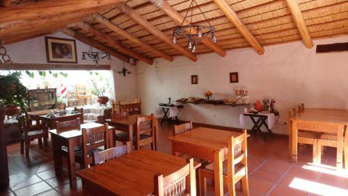 une salle à manger avec des tables et des chaises en bois dans l'établissement Del Amauta Hosteria, à Purmamarca