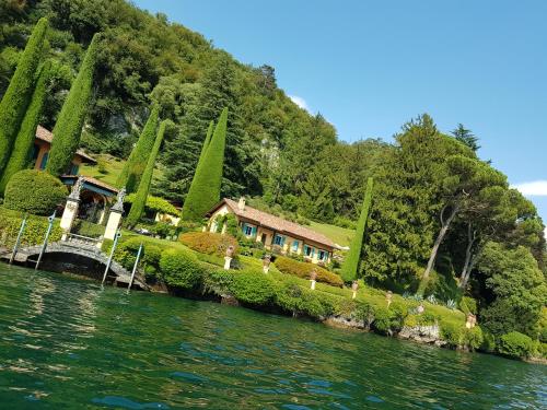 a house on a hill next to the water at Amata Valgre Affittacamere, comfort e pulizia eccezionali!! in Olginate