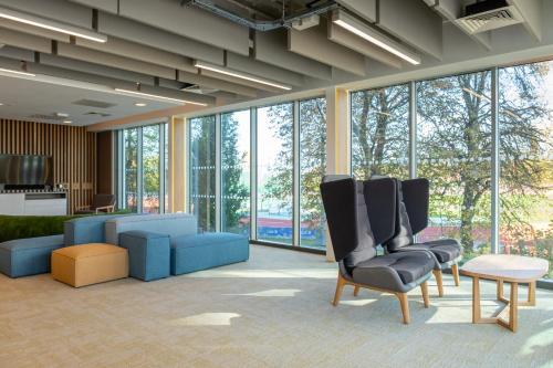 a lobby with chairs and a couch and windows at Elite Athlete Centre and Hotel in Loughborough