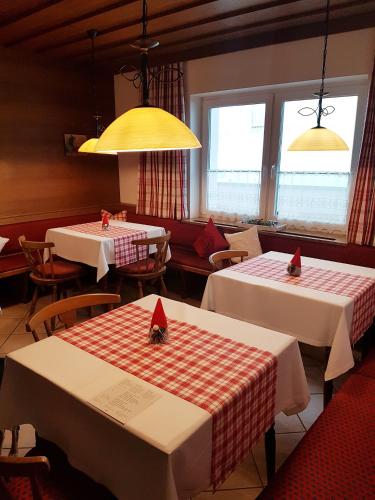 a dining room with two tables and a yellow light at Pension Haus in der Sonne in Fieberbrunn
