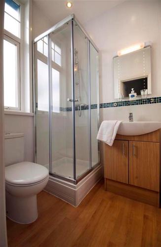 a bathroom with a shower and a toilet and a sink at The Paris Hotel in Coverack