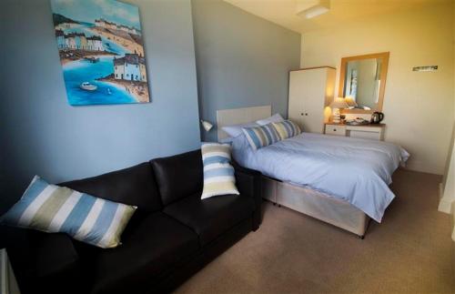 a bedroom with a bed and a couch in it at The Paris Hotel in Coverack