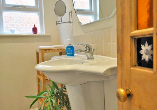 a bathroom with a white sink and a mirror at The Dairy House in Gosport