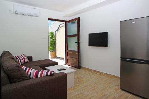 a living room with a couch and a refrigerator at Apartments Lena in Bol