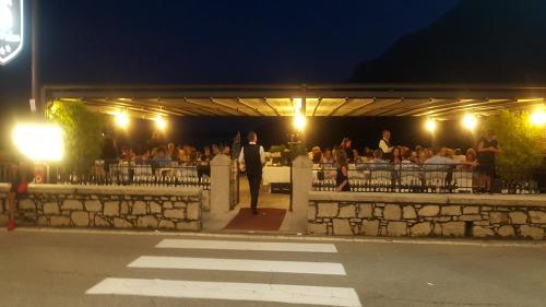 un gruppo di persone sedute al ristorante di notte di Hotel Bettina a Mergozzo