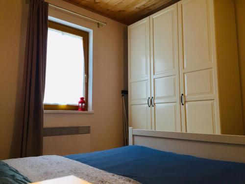 a bedroom with a bed and a window and a cabinet at House Arianna in Bad Kleinkirchheim