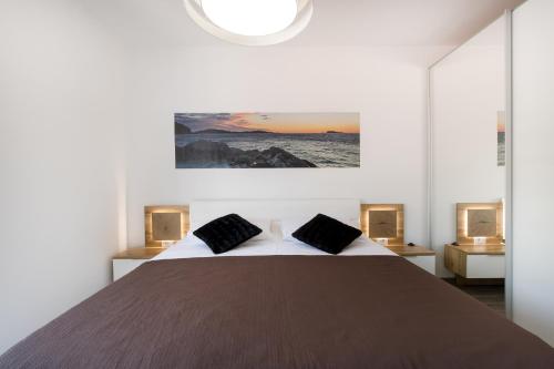 a bedroom with a large bed with two pillows at Marojica Apartments 2 in Cavtat