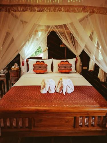 a bedroom with a bed with towels on it at Baan Sithepaban Guesthouse in Phitsanulok