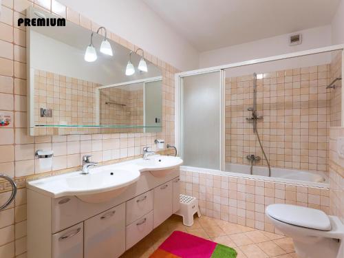 a bathroom with a sink and a tub and a toilet at Apartments Nives in Poreč