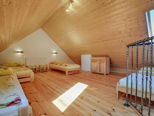 Cette chambre mansardée comprend deux lits et un plafond en bois. dans l'établissement Pensjonat Leśniczówka Apartamenty Gajówka, à Berezka