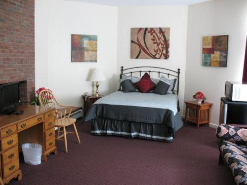 une chambre avec un lit, une télévision et un canapé dans l'établissement A Cambridge House Inn, à Cambridge